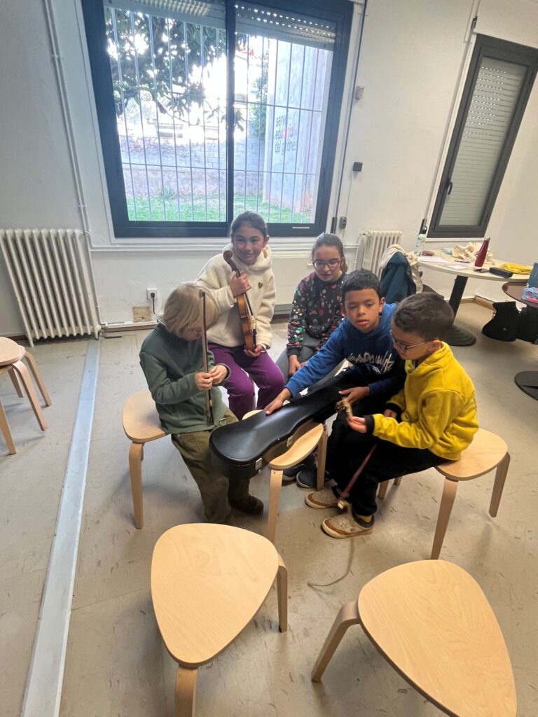 Nens i nenes miren i exploren un violí