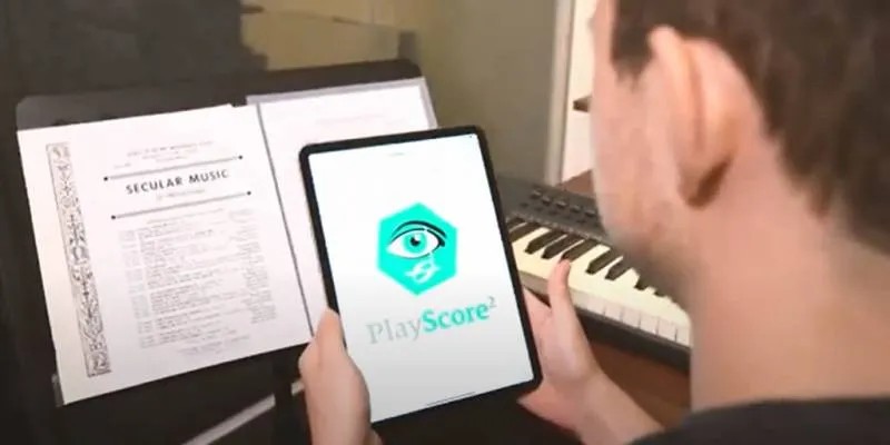 partitura i tablet amb playscore. Un alumne mira