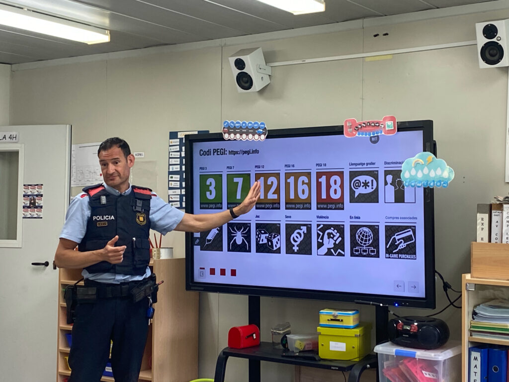 Un mosso fa una xerrada davant una pissarra digital.