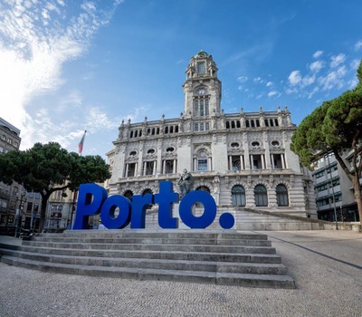 vista-del-ayuntamiento-de-porto-con-el-emblemático-cartel-azul-oporto-en-primer-plano-situado-la-plaza-liberdade-bajo-una-luz-407769702