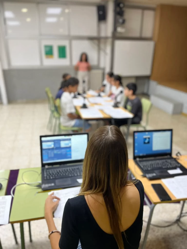 Es veuen uns alumnes usant l'ordinador per fer radio.