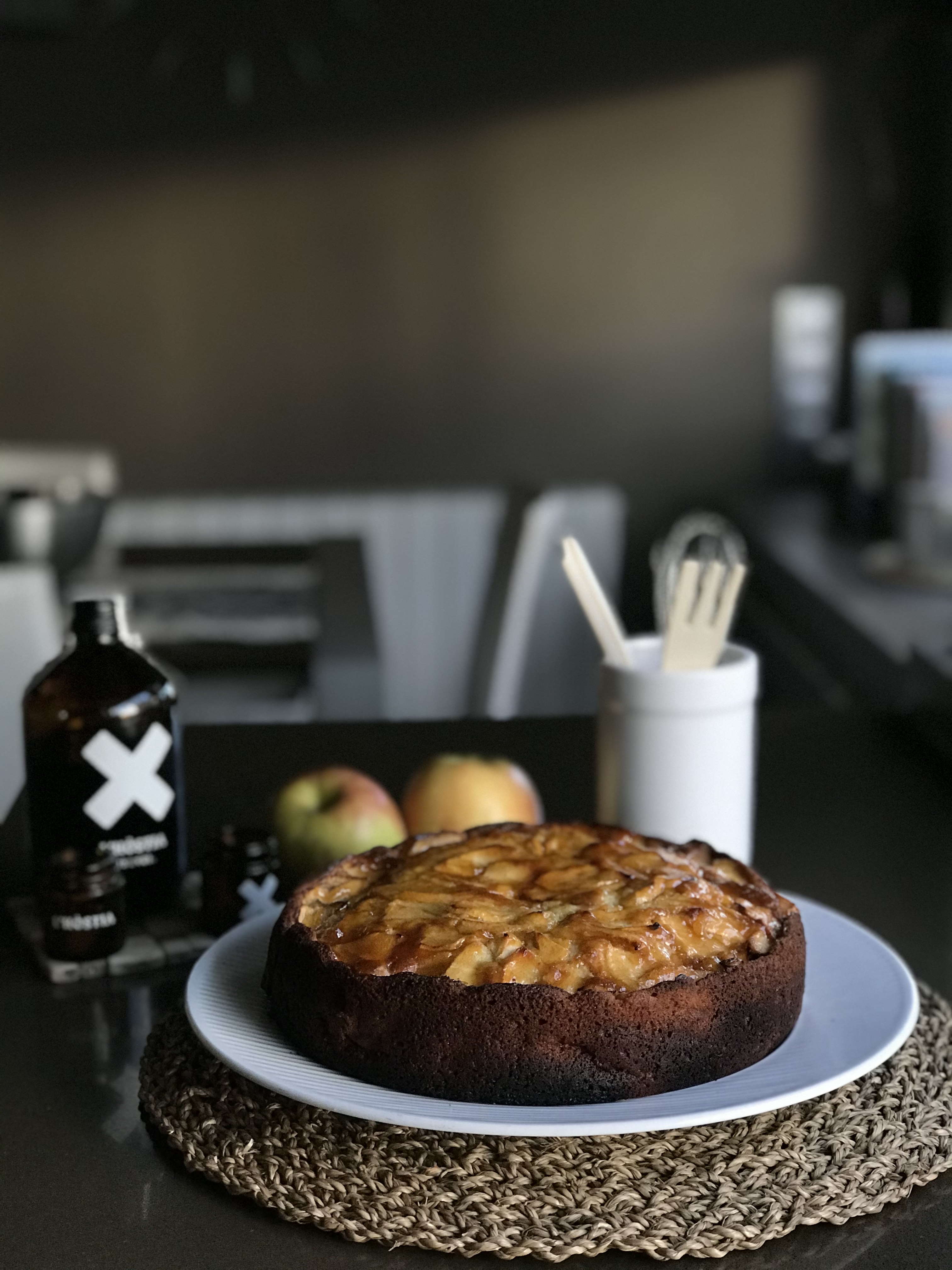 Imatge d'una cuina amb un primer pla d'un pastís i diferents elements d'una cuina