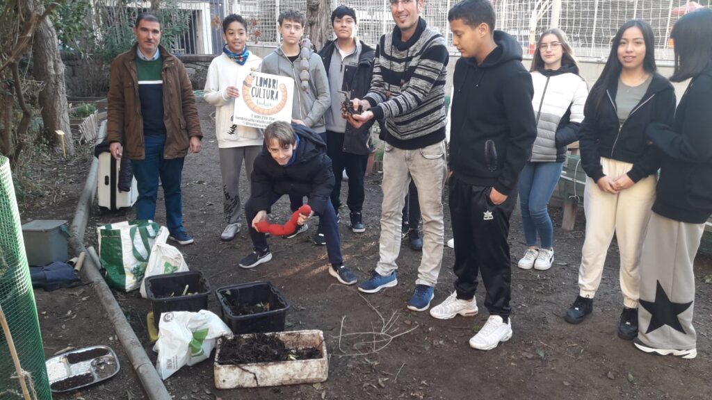 Alumnes a l'hort de l'institut Lluís Vives, veient com es prepara el vermicompost