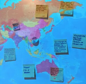 Un mapa d'Àsia projectat a la pantalla, amb diferents post-its enganxats amb missatges en francès, escrits a mà.