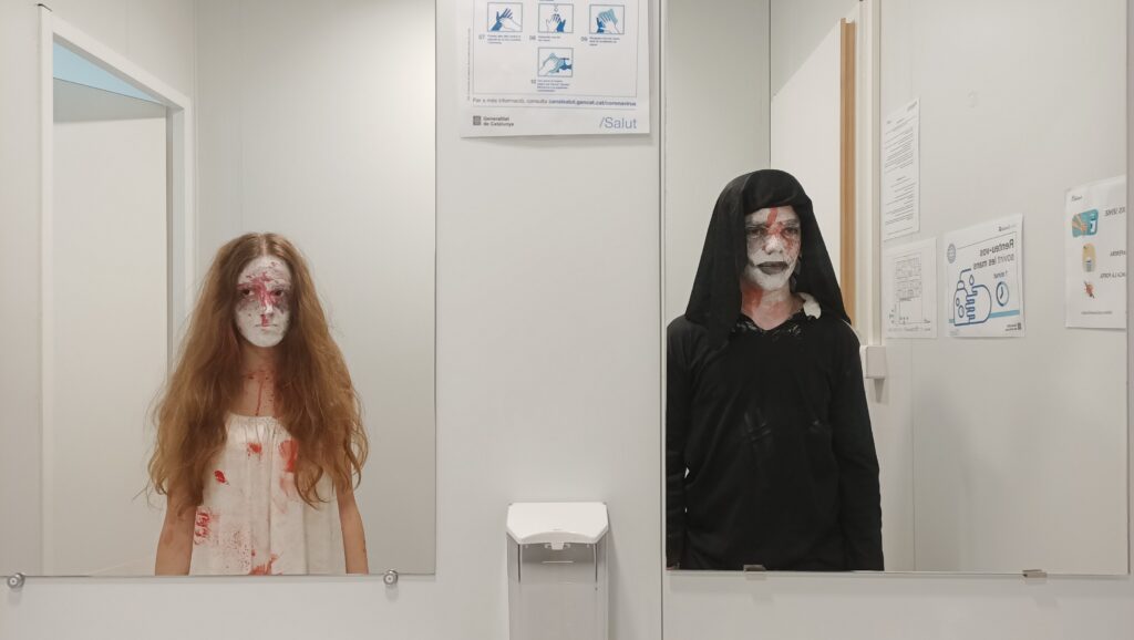 Dos alumnes disfressats de Halloween es miren al mirall