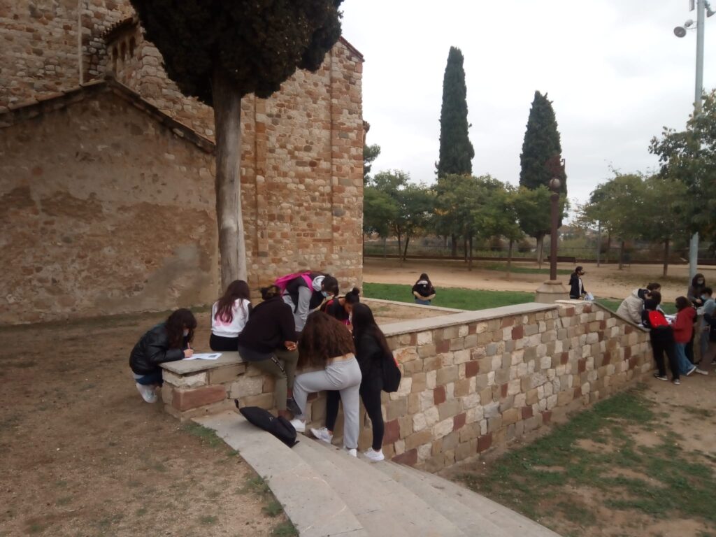Alumnes de 2n d'ESO a l'exterior de l'Església de Santa Maria a Barberà del Vallès treballant en equip.