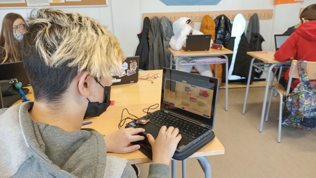 Un alumne programa amb una placa micro:bit