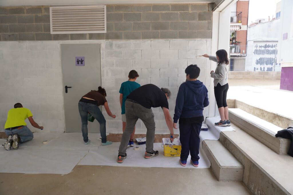 Professorat i alumnat pinta una paret del pati