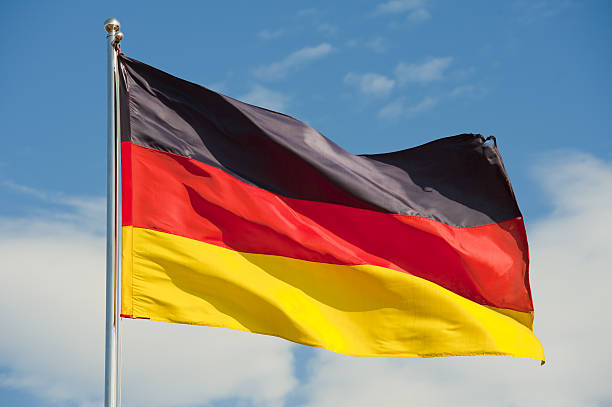 german flag on a pole over beautiful sky