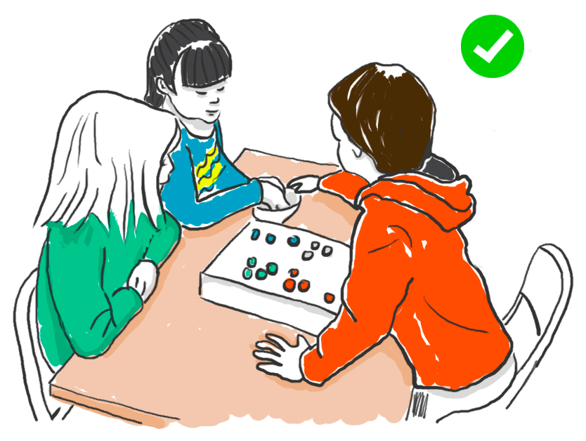 2 nenes i un nen jugant a un joc de taula